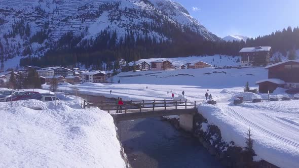 Aerial drone view of a man and woman couple lifestyle at a bridge in the snow at a ski resort