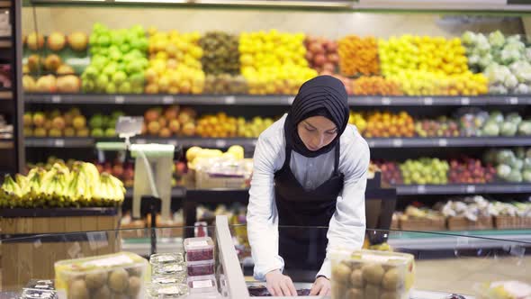 Muslim Woman Rearrange the Products in the Supermarket