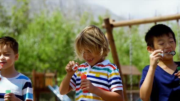 Schoolkids playing with bubble wand in playground