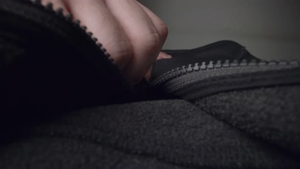 Extreme Close Up Zipper with Hand Unzipping the Sweater Jacket Zipper