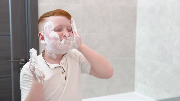 Funny Boy in the Bath Smears His Face with Shaving Cream the Child Imitates an Adult Dad Shaves