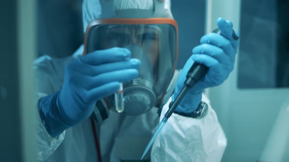 A Man in Hazmat Uses Pipette and Tube While Working in Laboratory. Covid19, Coronavirus Concept.