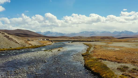 Aerial drone of an empty natural river in the high-altitude alpine orange plain of Deosai National P