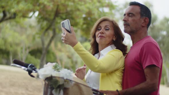 Happy Caucasian Couple Looking at Camera Taking Selfie on Phone