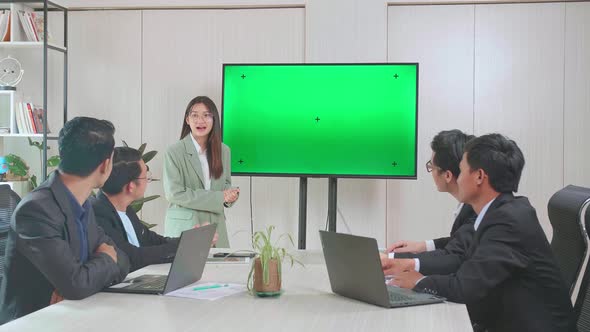 Young Asian Businesswoman Presentation To Her Business Colleagues With Tv Green Screen, Celebrate