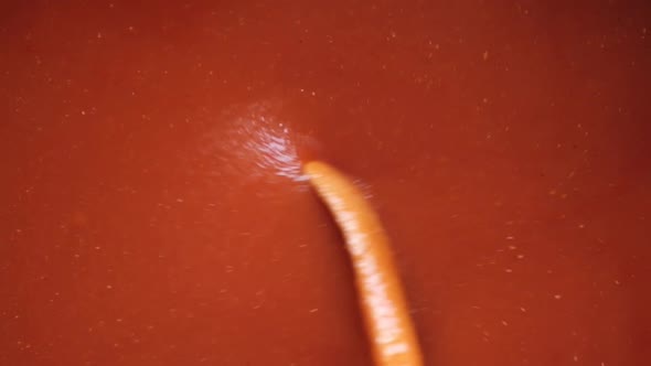 Stirring Tomato Sauce with Wooden Spoon