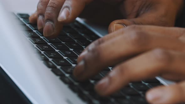 Close Up Hands of a Black Man Typing on the Laptop Keyboard