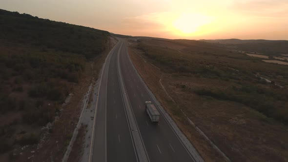 Top Shot of White Cargo Truck Driving at Sunset Road