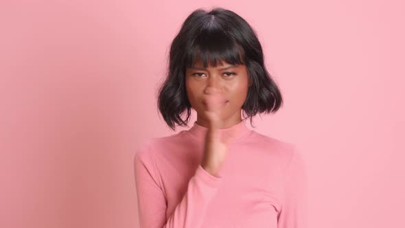 Woman Waves Palm Near Nose Smells Unpleasant Stench Over Pink Background