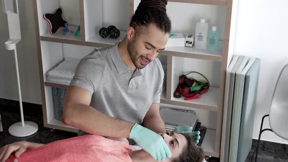 Physiotherpist doing jaw massage on female patient