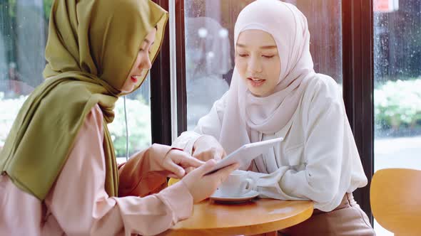 Young beautiful Asian Muslim women enjoying a relaxing moment working and playing with mobile phone