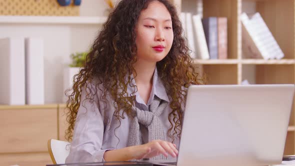 Asian girl finished computer work,  stretching relaxing seated at workplace feeling stress relief, s