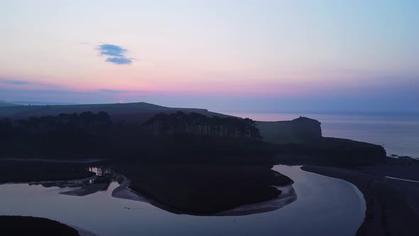 Aerial drone birds eye view of coastal beach landscape at twilight sunrise, Devon England