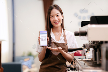 A woman is holding a phone with a QR code on it