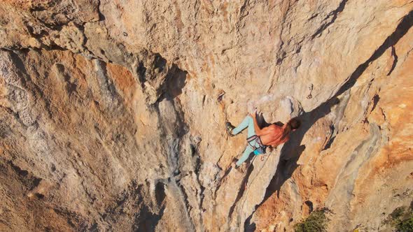 Aerial Point of View From Drone of Strong Muscular Man Climbs Challenging Rock Climbing Route