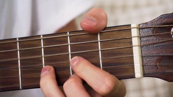 Closeup of guitarists fingers playing fast chord progression