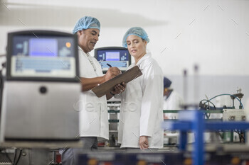 Lab technicians checking equipment at packaging factory lab