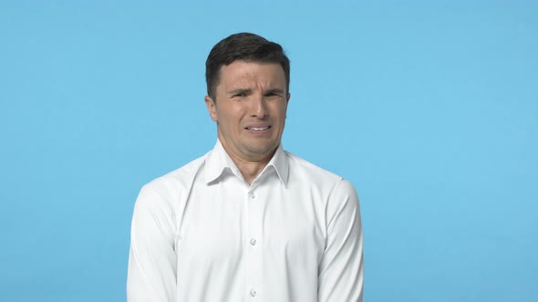 Slowmotion Adult Caucasian Man in White Shirt Cringing Grimacing From Aversion Feeling Strong