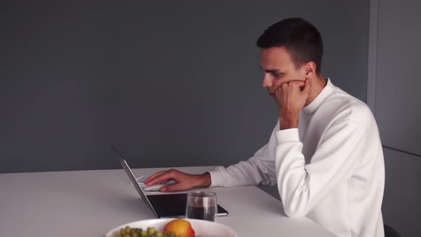 Thoughtful Serious Young Man Student Writer Sit at Home Office Desk with Laptop Thinking of