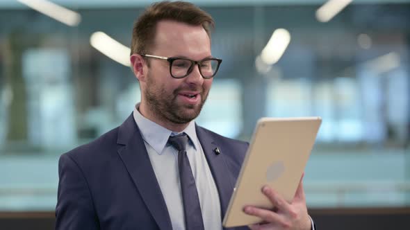 Portrait of Video Call on Tablet By Middle Aged Businessman