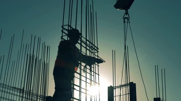 Builder Is Working with a Metal Framework on Top of a Building