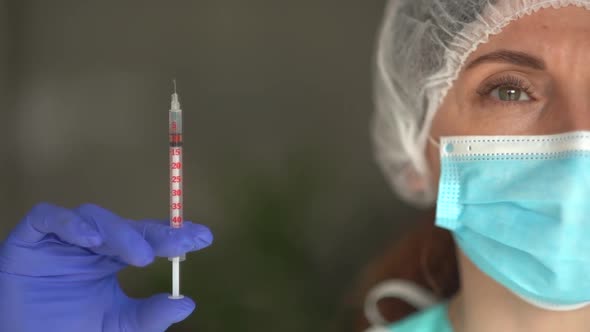 Portrait of a Nurse Wearing a Mask and Gloves Holding a Syringe Possible Cures Against Viruses and