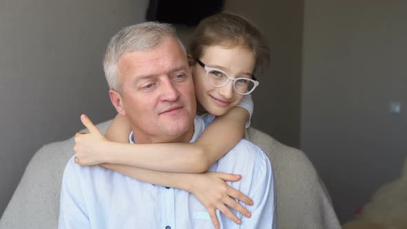 Family Portrait of Mature Father and Little Blonde Daughter Hugging at Home While Celebrating Father