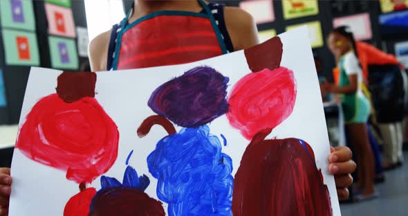 Happy girl showing her painting in drawing class