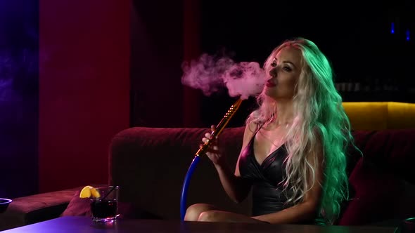 Portrait of Young Curly Blonde Woman Resting in the Hookah Room. Slow Motion