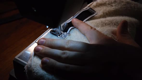 Sewing Machine Needle in Motion. Close-up needle rapidly moves up. The tailor sews towel.