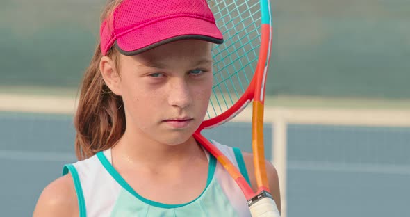 Closeup View of a Female Player Wearing Pink Baseball Cap and Holding a Racket