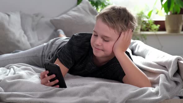 Boy Using Smart Phone Looking at Mobile Screen Making Conference Call in App