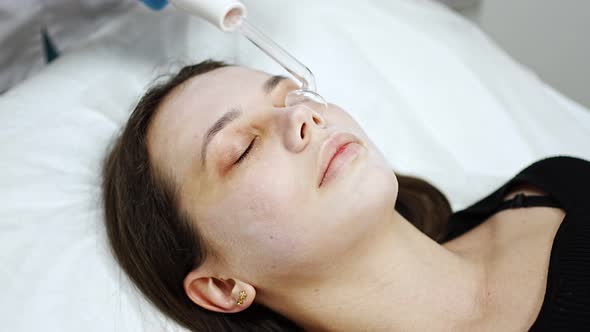 Beautician Uses the Darsonval Device on the Client's Face