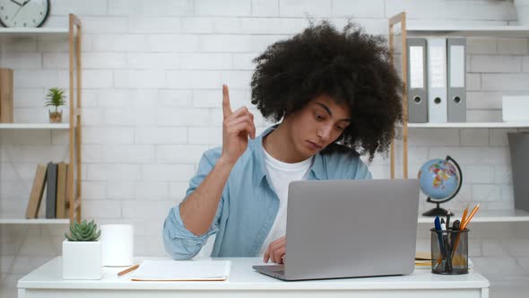 Male Student At Laptop Having Great Idea Writing Article Indoors