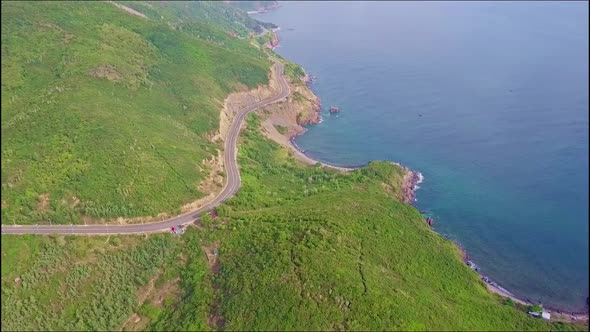 Drone Flies From Ocean Coast Along Highway and Above Hills