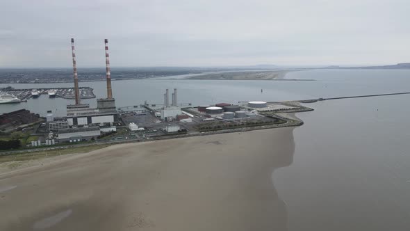 Power Plant At Dublin Port In Ireland With View Of Poolbeg Beach. aerial, panning left