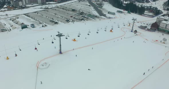 Aerial View: Ski Resort, Slope and Chair Lift. Cableway Lifts Skiers To the Mountain Hill. Winter