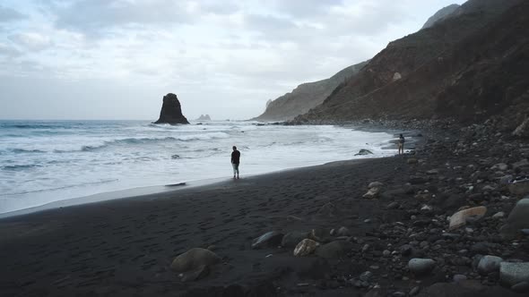 Young Man Tourist Goes Down the Long Stairs to the Famous Volcanic Black Sand Beach Benijo in the