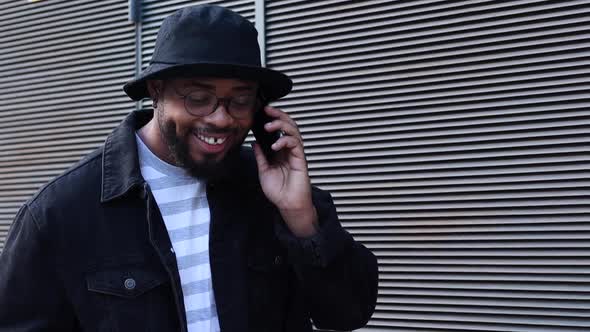 Laughing black man talking smartphone