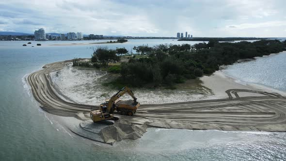 Large machinerying sand on a coastal rejuvenation project close to a urban city skyline. Panoramic d