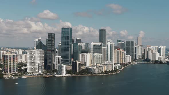 Gorgeous aerial view of Brickell waterfront downtown Miami cityscape parallaxing clouds 4K