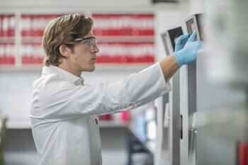 Scientist operating a touchscreen panel in a lab