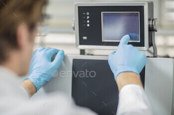 Technician operating a touchscreen device in a lab