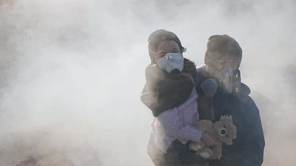 The surviving father carries his daughter in a gas mask through clouds of toxic smoke