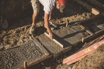 Builder laying cement foundation