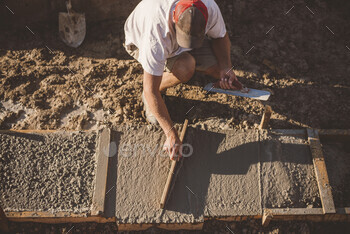 Builder laying cement foundation