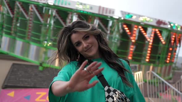 Young woman waving to the camera as she smiles