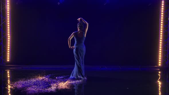 Attractive Sexy Woman Dancing Flamenco Elements in a Dark Studio on the Water Surface