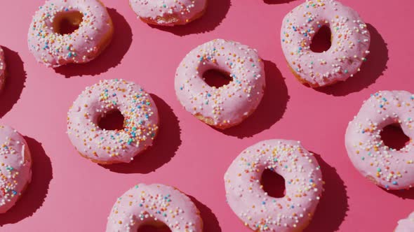 Video of donuts with icing on pink background