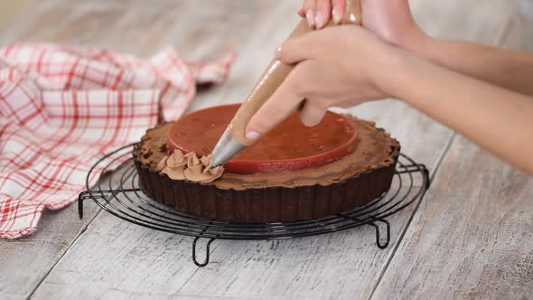 Confectioner Decorates Delicious Chocolate Tart with Cherry Confit and Chocolate Cream.